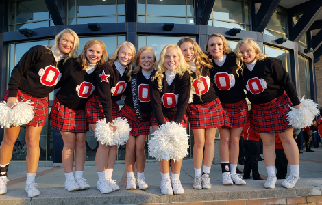 Cheerleaders in uniform in front of commons